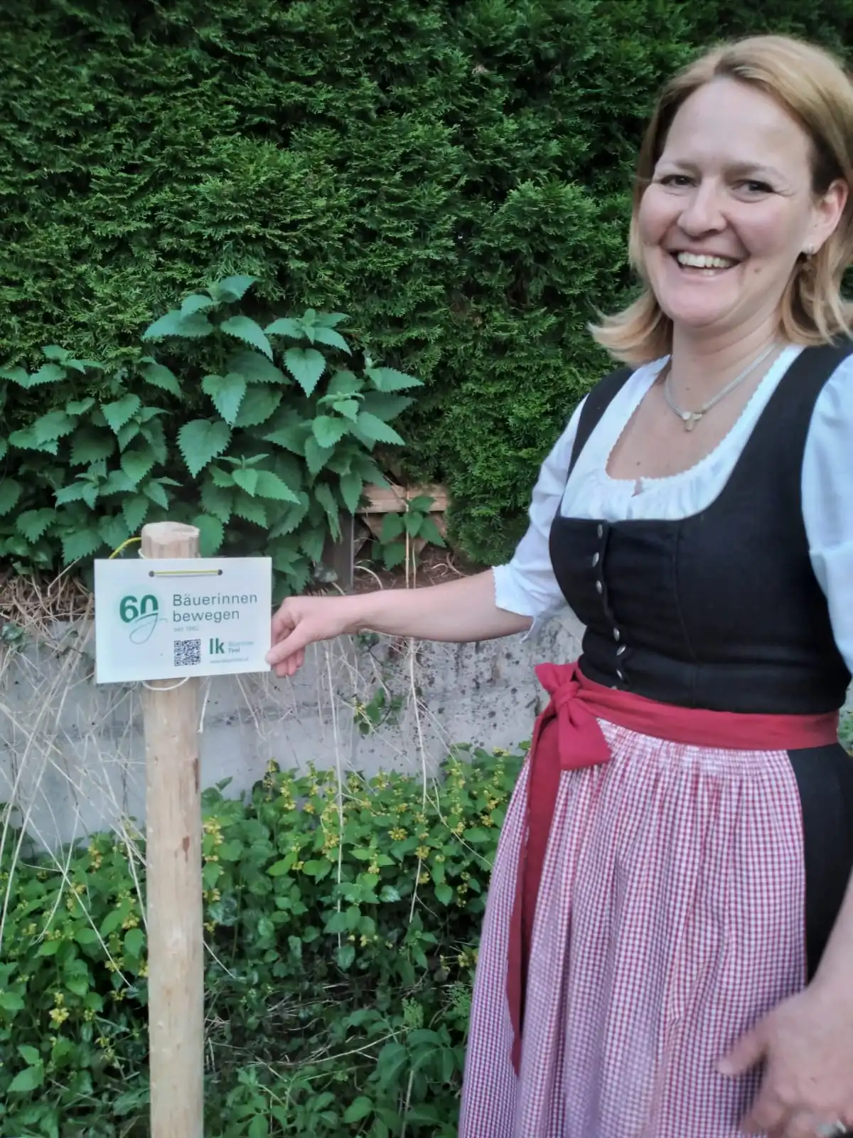 Ortsbäuerin Lisbeth Werlberger mit Hinweisschild "60 Jahre Bäuerinnen bewegen"