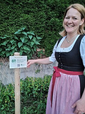 Ortsbäuerin Lisbeth Werlberger mit Hinweisschild "60 Jahre Bäuerinnen bewegen"