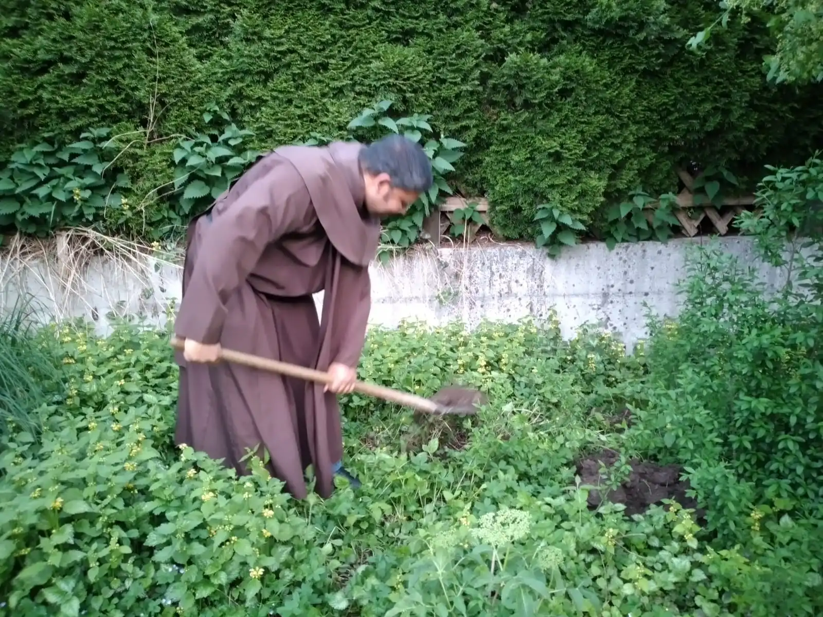 Pater Charles mit der Schaufel bei der Arbeit